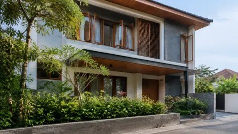 Rumah dua lantai dengan bukaan jendela dan peneduh fasad