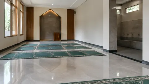 Ruang musala berkarpet dengan ceruk dinding dan jendela