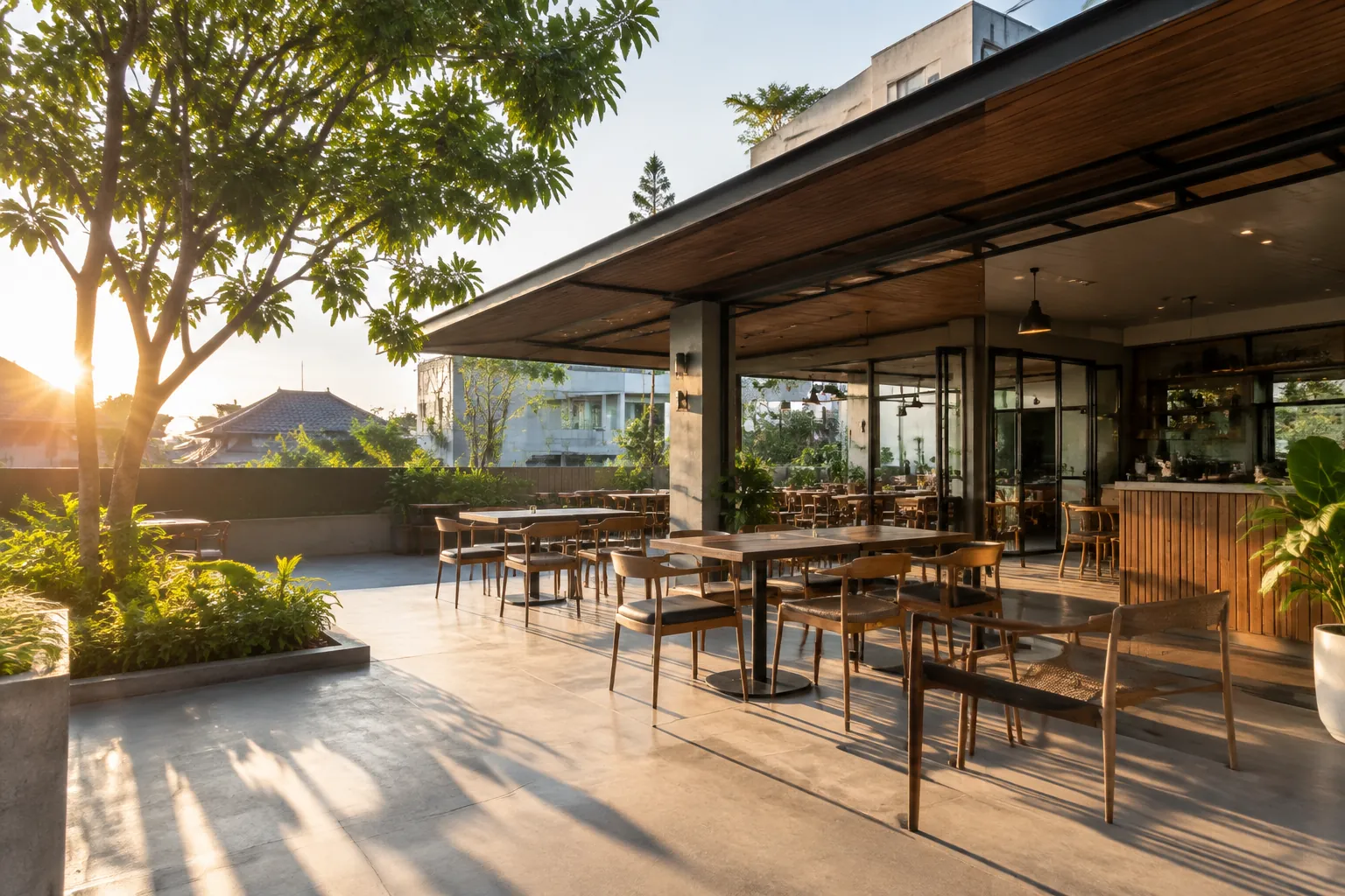 Matahari sore menerangi teras makan terbuka di depan kafe