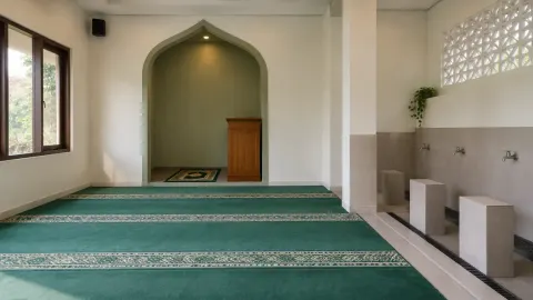 Ruang musala berkarpet dengan ceruk dinding tanpa tulisan