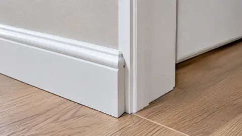 Trim putih pada sudut dinding dekat pintu