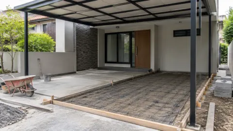 Carport dalam tahap pekerjaan lantai di depan rumah