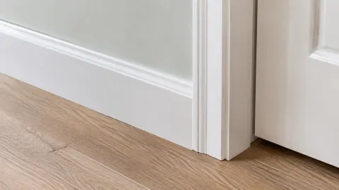 Trim putih pada sudut dinding dan kusen kamar kecil