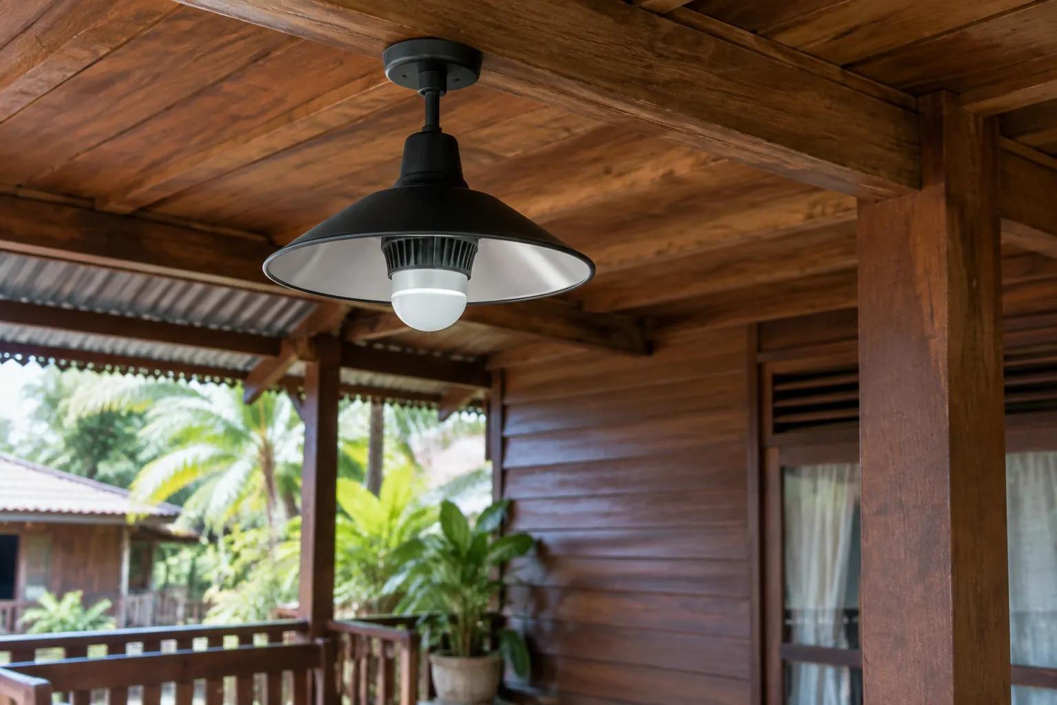 Lampu gantung pada teras kayu rumah panggung