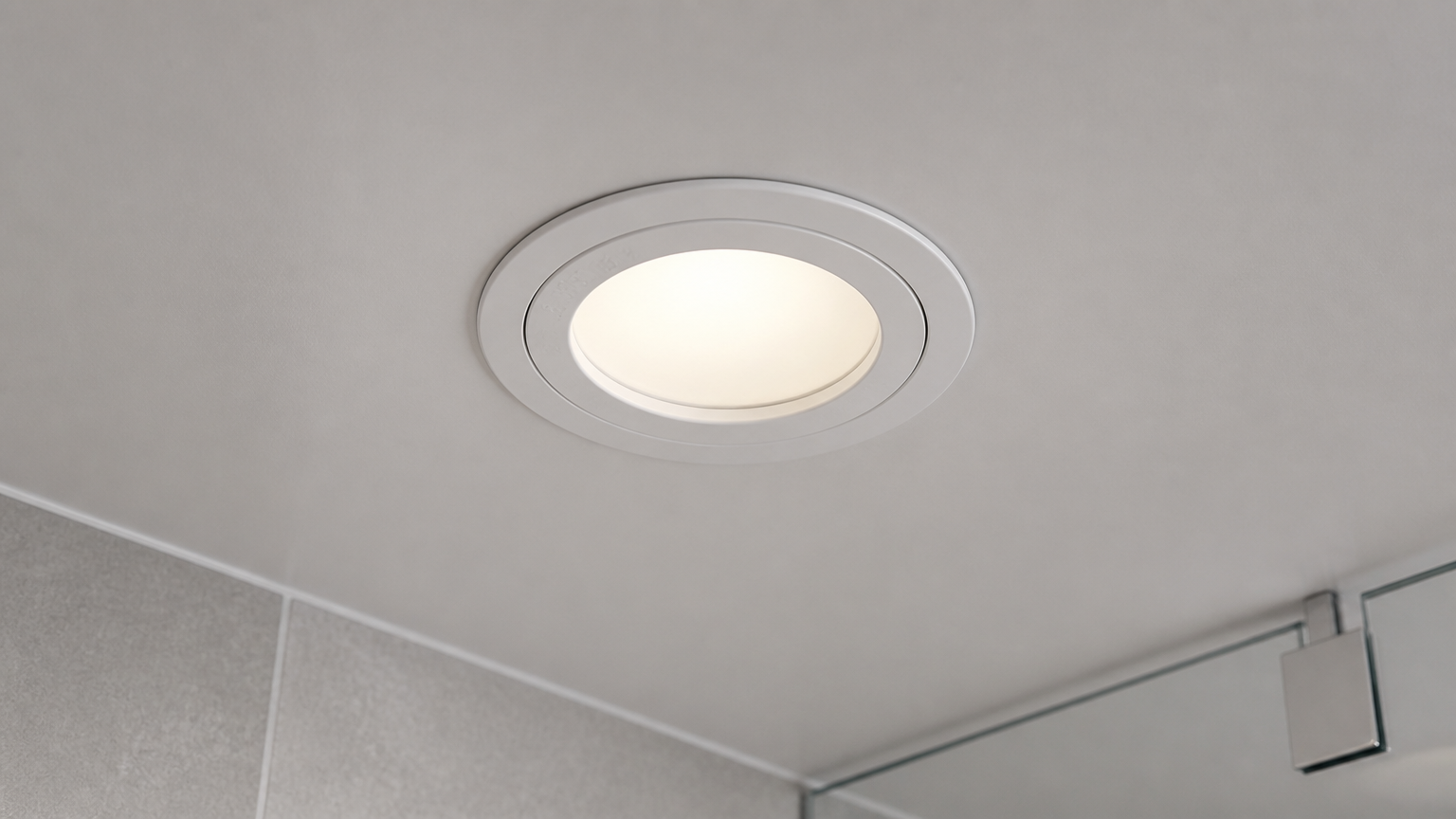 Lampu plafon bulat di atas partisi kaca kamar mandi