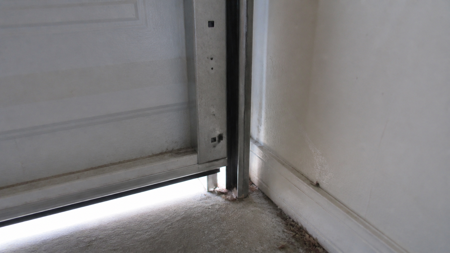 Celah di bawah pintu garasi Cahaya masuk melalui celah bawah pintu garasi di dekat lantai
