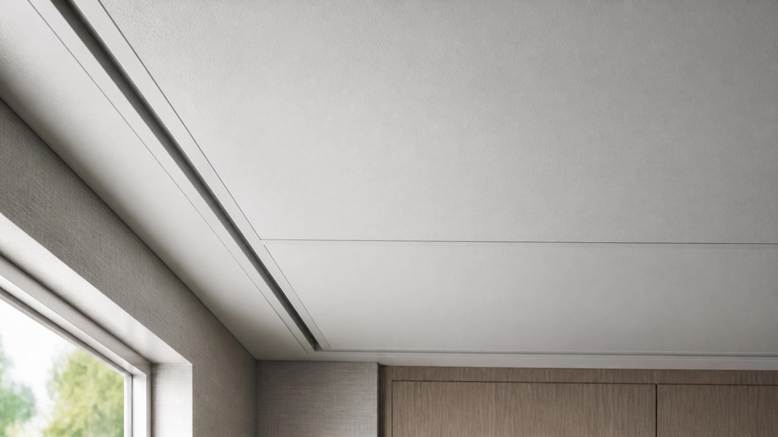 Celah ventilasi linear mengikuti tepi plafon putih di atas jendela
